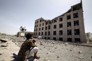 A Houthi militant sits amidst debris from the Yemeni Football Association building, which was damaged in a Saudi-led air strike, in Sanaa May 31, 2015. REUTERS/Mohamed al-Sayaghi